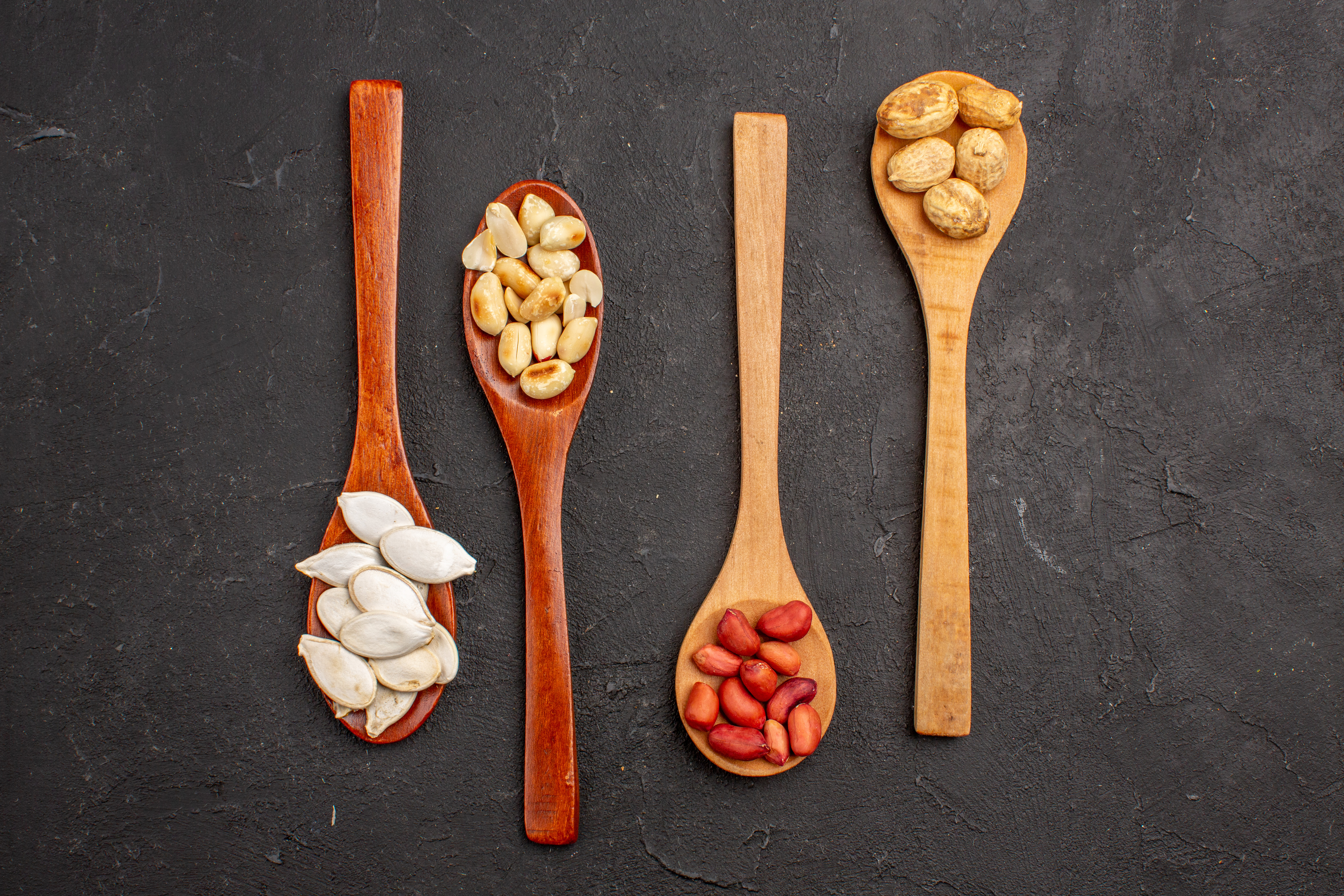 Küchenbrett mit Maßlöffeln und Nüssen